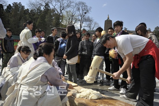 한국 천태종이 마련한 떡(인절미) 만들기 체험장에서 한 중국인이 떡메치기를 하고 있다.