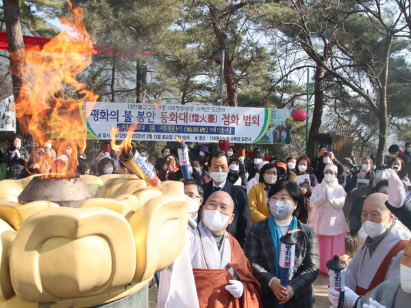 도안사 회주 혜자 스님과 내빈들이  등화대에 평화의 불을 점화하고 있다.