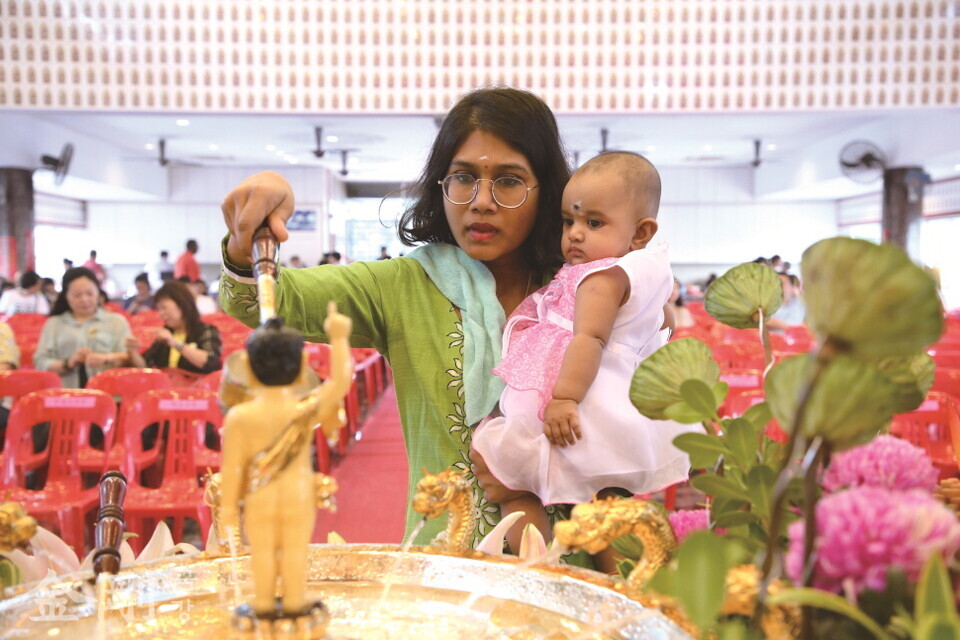 2019년 5월 19일 부처님오신날 말레이시아 쿠알라룸푸르의 한 사찰에서 아기를 안은 불자가 관불의식을 하고 있다. 〈사진=GettyimagesBank〉