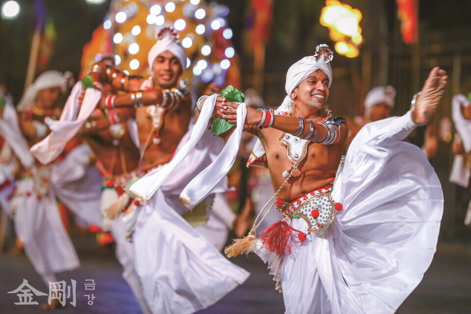 전통 복장을 한 예술가들이 치아사리 행렬 앞에서 춤을 추고 있다. 그런데 축하 퍼레이드 참가를 예술가로 제한하고 있어서 일반인들 은 거리에서 구경만 해야 한다.  〈사진=스리랑카관광진흥국〉