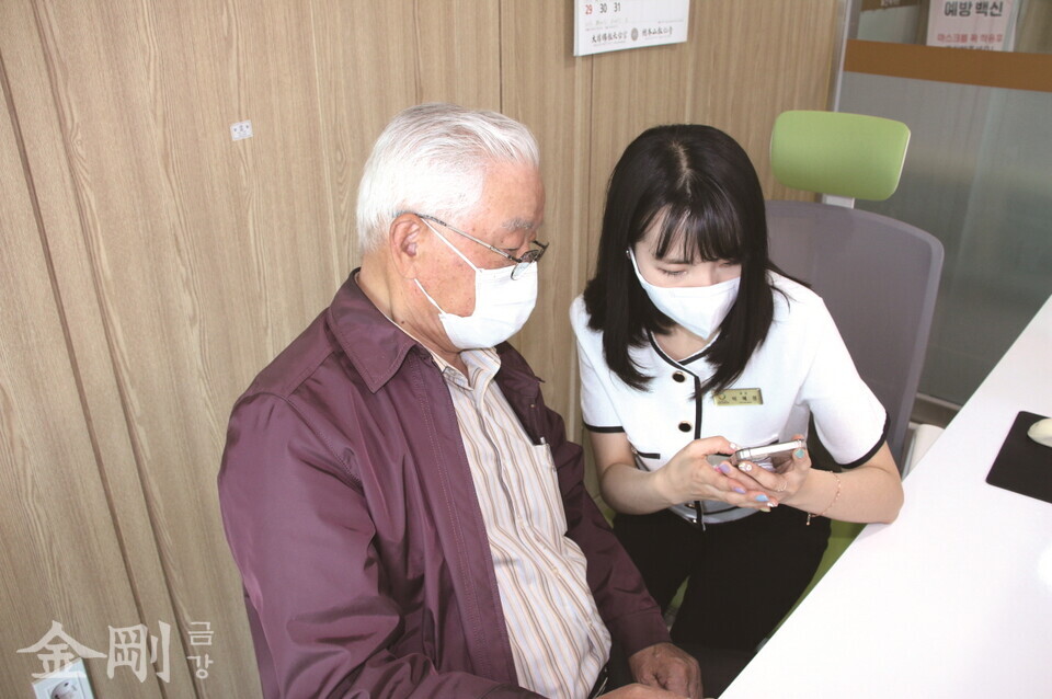 박혜정 팀장이 어르신에게 스마트폰 사용법을 알려주고 있다.
