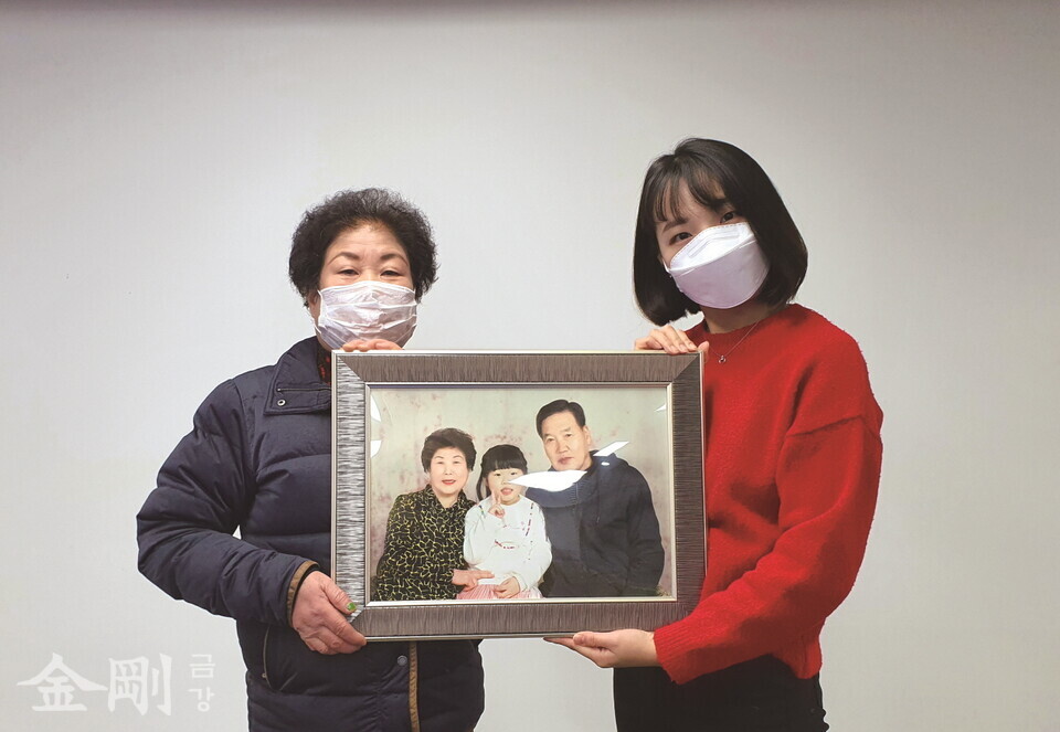 박혜정 팀장이 가족기능지원사업 일환인 가족사진 촬영에 참여한 어르신과 어르신의 가족사진을 들어 보이고 있다.