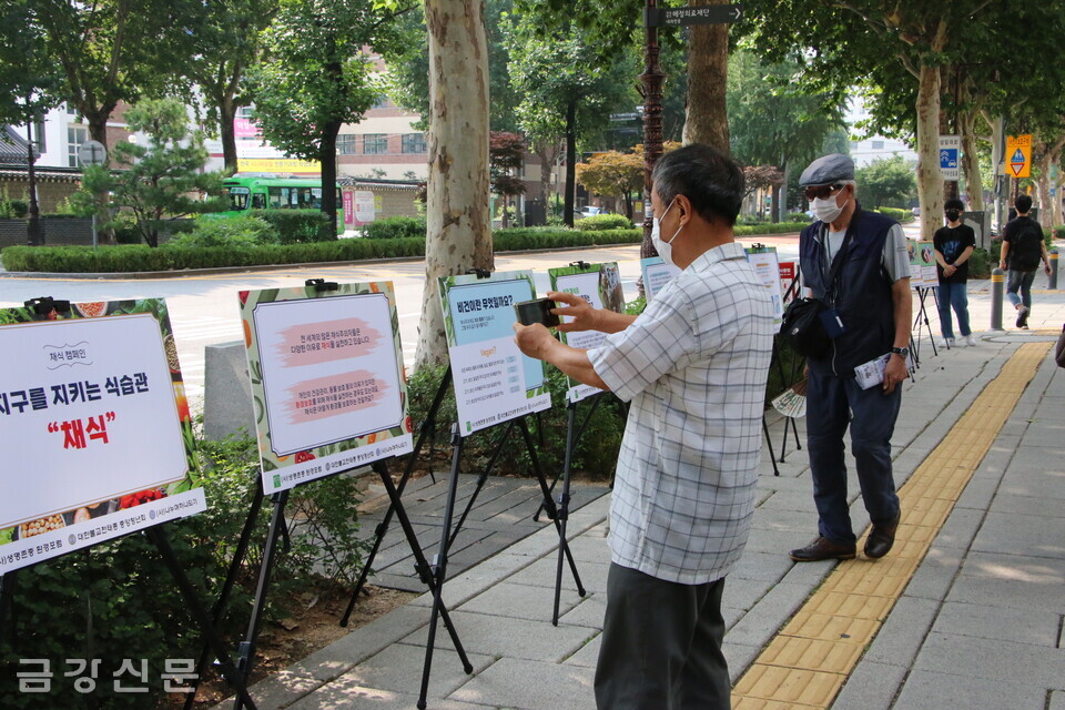 지난 7월 종로 일대에서 펼쳐진 거리환경 캠페인에서 지나가던 시민이 홍보물을 촬영하고 있다.