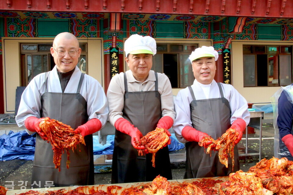 김치나눔 행사에 동참한 (오른쪽부터)무원 스님과 김영환 충북도지사, 도웅 스님이 김치를 들어올리며 웃어 보이고 있다.