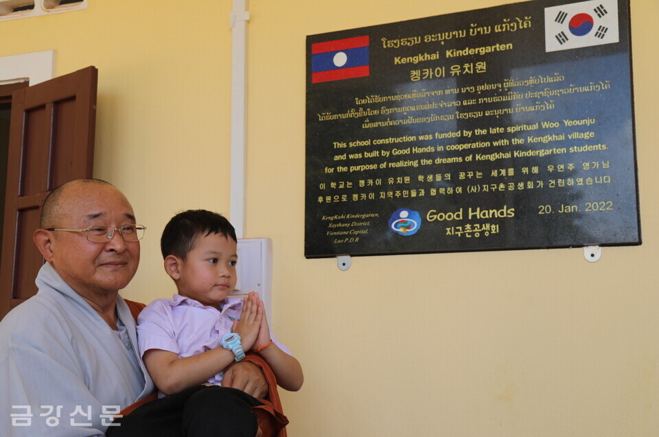 켕카이 유치원 현판식 이후 이사장 성우 스님이 한 아이와 함께 기념사진을 찍고 있다.