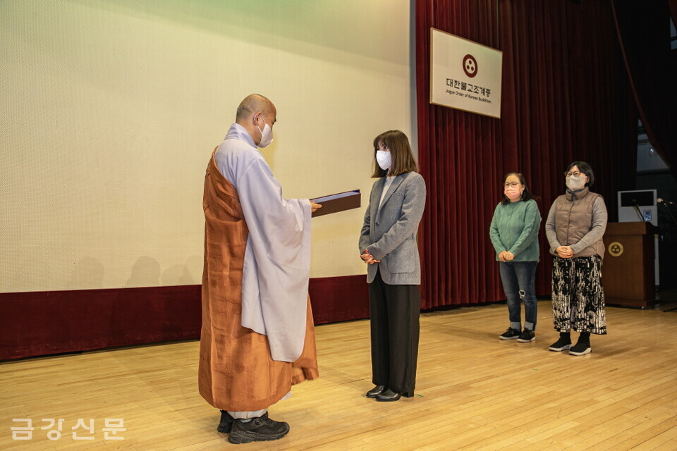 한국불교문화사업단장 원명 스님이  루마니아 출신의 합격자 박클라우디아디아나 씨에게 자격증을  수여하고 있다.