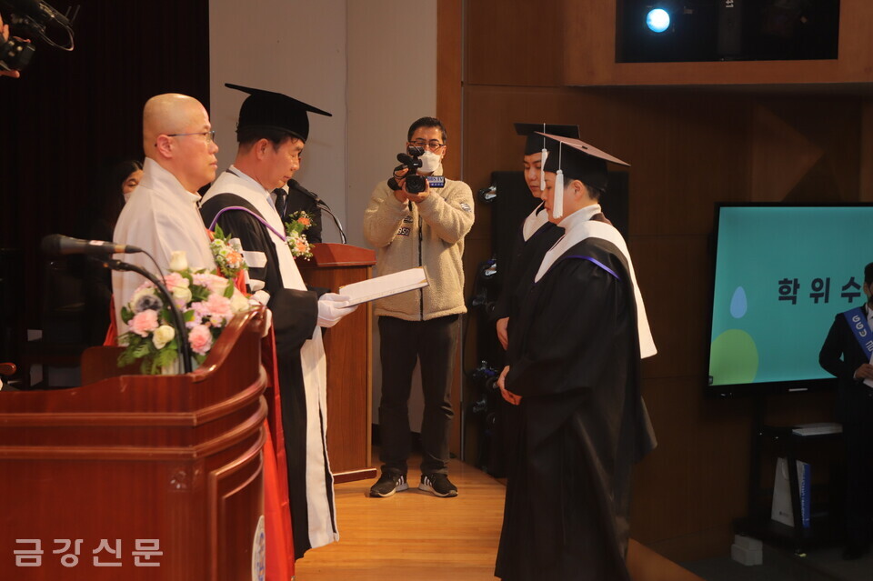 금강대 총장 직무대행 거성 스님이 김영임·이상권 씨에게 문학석사 학위증을 전달하고 있다.