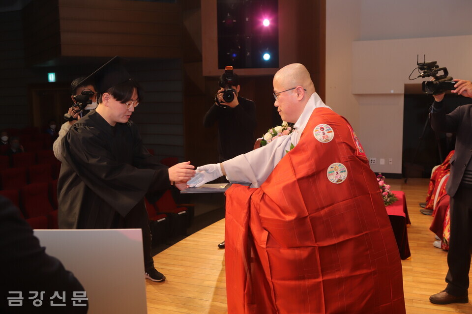 학사 졸업생 중 차차석을 차지한 박영서 씨에게 총장상을 수여하고 있는 총장 직무대행 거성 스님.