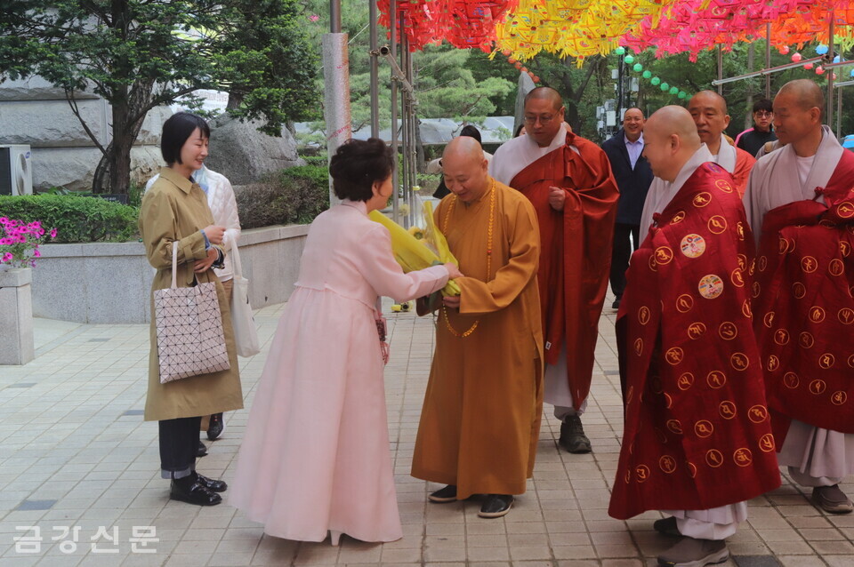 관문사 불자가 중국불교협회 부회장 밍셩 스님에게 꽃다발을 전하고 있다.
