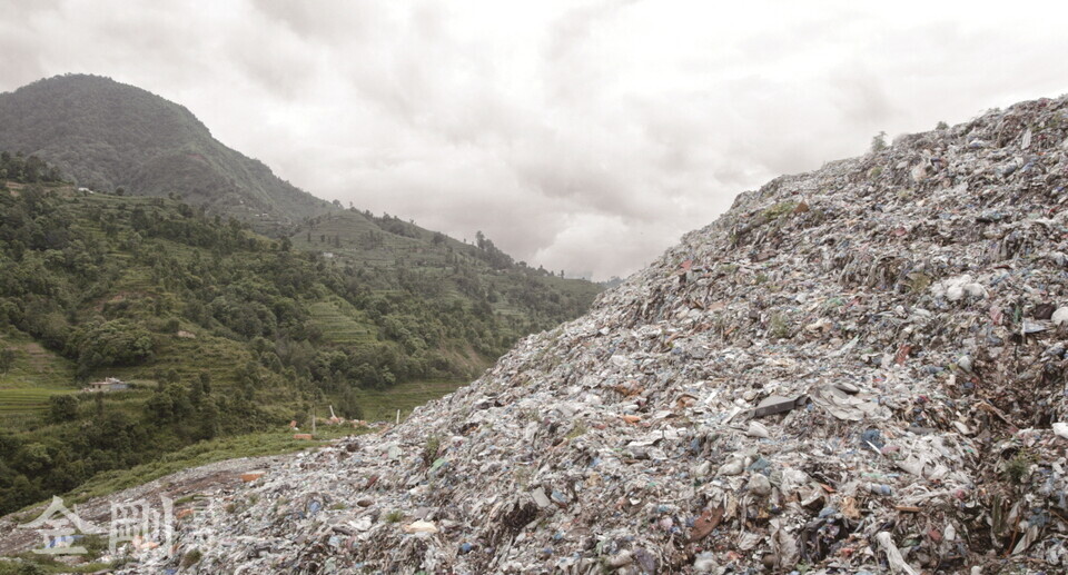 네팔의 쓰레기산과 청정한 푸른 산의 모습이 대비를 이룬다.