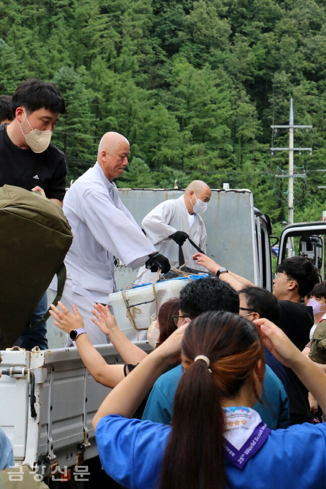 종단 스님들이 일본 스카우트단 참가자들의 짐을 건네주고 있다.