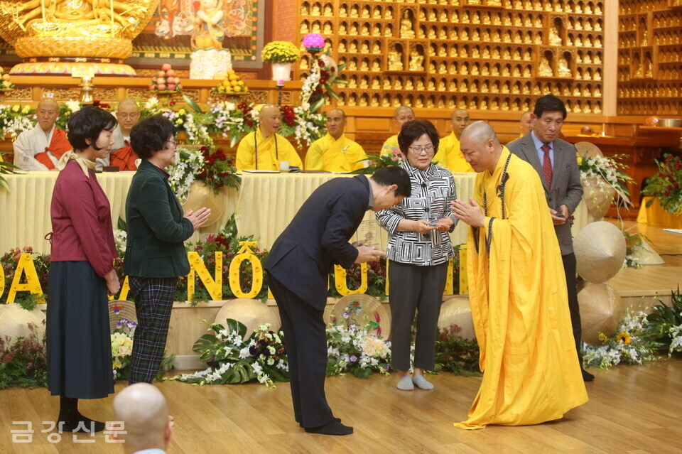 틱 티엔 투언 스님이 명장사 신도회 간부들에게 선물을 전달하고 있다.
