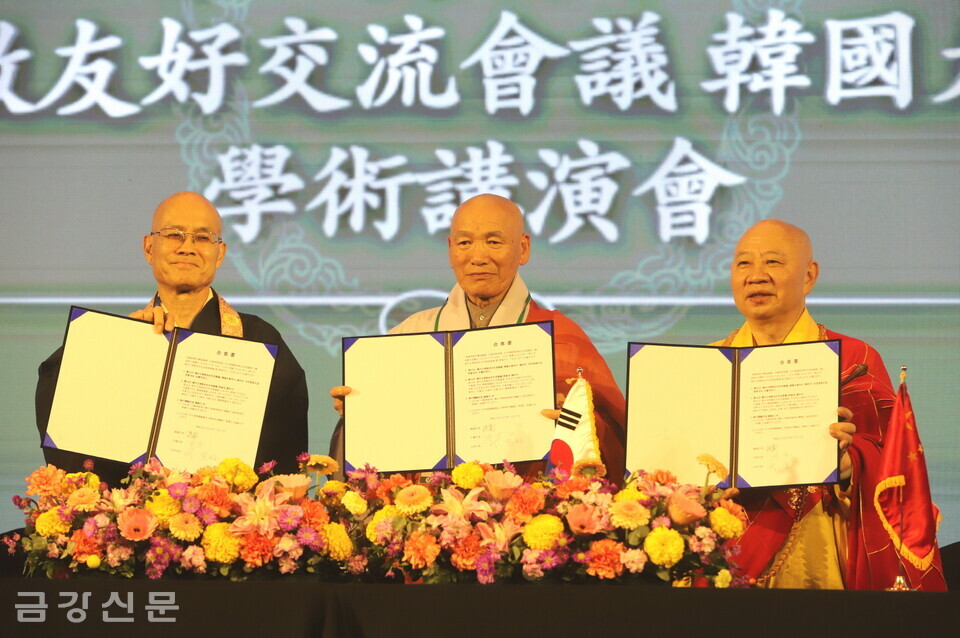 한국 측 종단협 사무총장 도각 스님(가운데), 중국 측 명생 스님(오른쪽), 일본 측 다케 가쿠쵸 스님은 공동선언문에 서명한 뒤 합의서를 들어 보이고 있다.