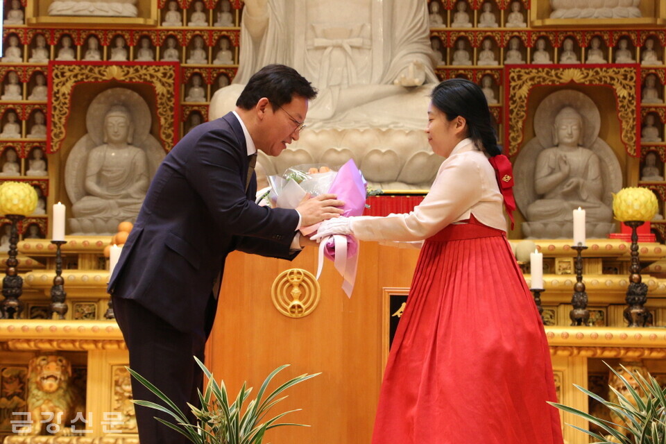 김형동 회장이 관문사 청년회 대표에게 축하 꽃다발을 건네받고 있다. 